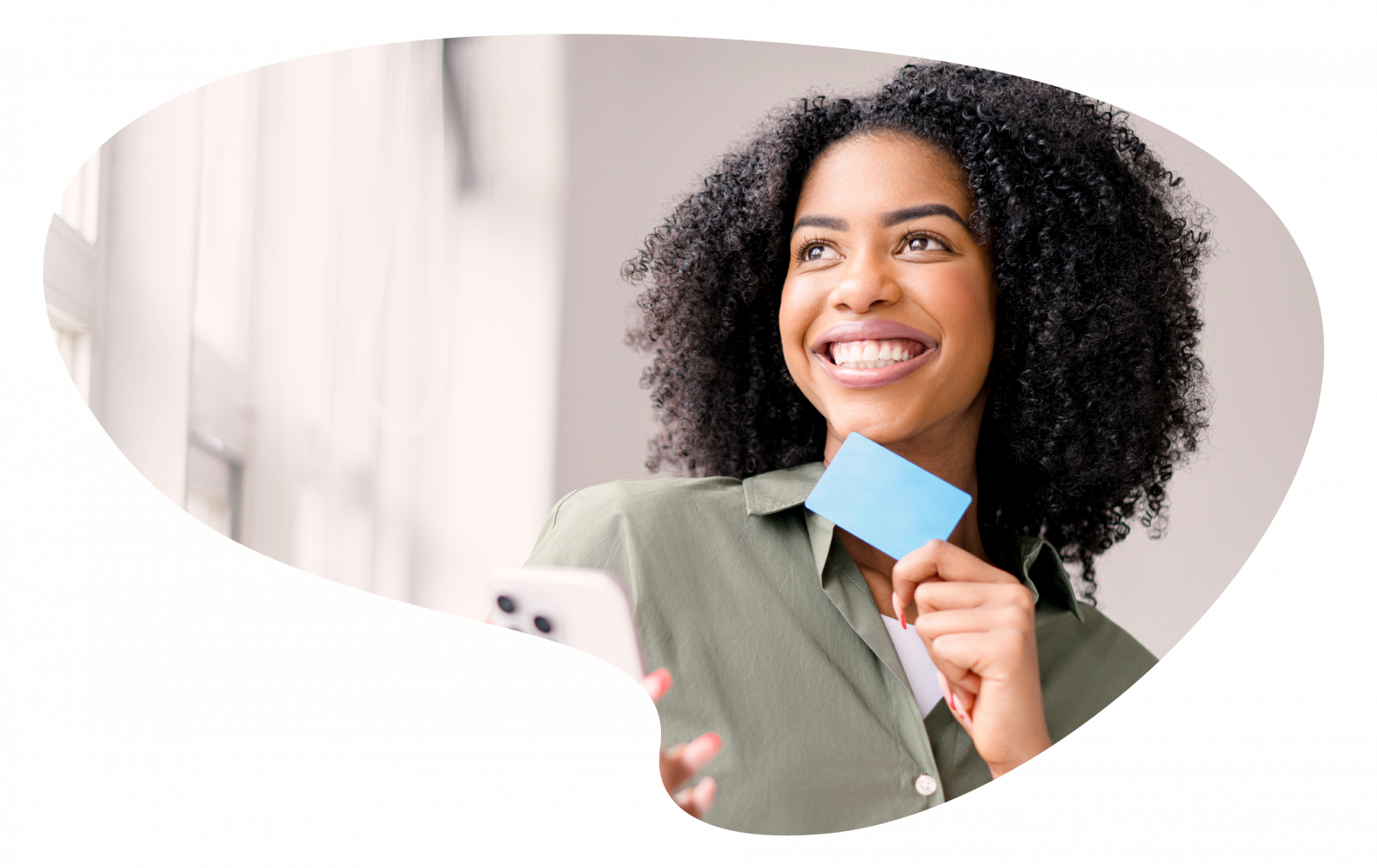 La production et la personnalisation de cartes jouent un rôle central pour les entreprises du retail. Numen vous accompagne dans la confection de ces cartes et badges. Image d'une femme, en intérieur, souriante avec une carte et un téléphone portable dans les mains.