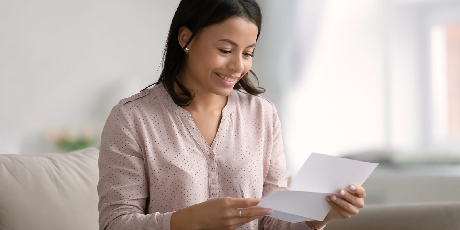 L'externalisation de la production de lettres chèques a de nombreux avantages. Image d'une femme ouvrant un courrier.