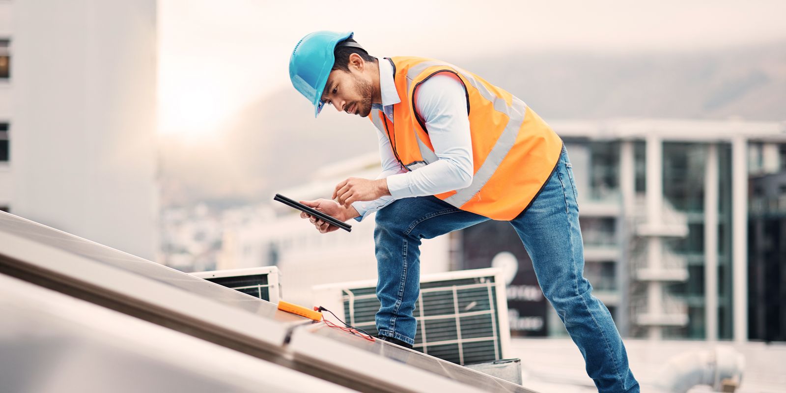 Témoignage client Total. Image d'une homme avec un casque de chantier sur un toit. Image symbolisant le secteur de l'énergie